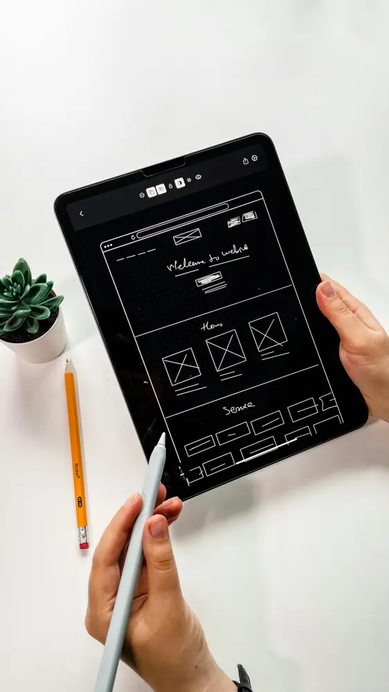 Wireframe digital de landing pages de alta conversão sendo desenhado em tablet, mostrando estrutura de seções para criação no Elementor